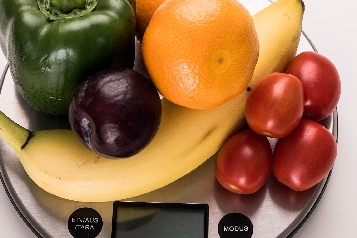 Verschiedene Sorten Obst und Gemüse auf einer Küchenwaage